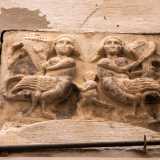 L'immagine ritrae due arpie, creature mitologiche met� donna e met� uccello legate al regno simbolico del male e dell�avidit�. Le figure, rappresentate con volto serioso e con delle lunghe code, sono intente a suonare strumenti musicali: un�arpa e una specie di violino. Al centro invece � raffigurato un fanciullo nudo privo di volto che tende il braccio sinistro verso una delle due